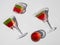 Four crystal glasses with bright red and green filling inside lie against light background