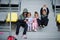 Four cuttie kids sitting on sport area and looking at mobile phone