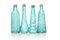 Four cyan colored glass bottles of different shapes