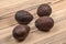 Four dark brown ripe avocados on wooden boards