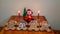 Four decorated ginger man cookies on a table with candles, small Christmas tree and a Santa Claus figure