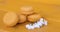 Four delicate yellow almond cakes on a yellow background with white flowers