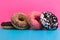 Four different donuts on blue and pink background