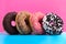 Four different donuts on blue and pink background