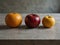 four different fruits a wooden table a red apple Capturing Citrus Splendor The Art of Photographing