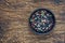 Four different kinds of peppercorns in clay bowl on wooden background, copy space, top view