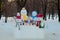 Four different size dressedsnowmen and animals made of snow near trees outdoors in winter