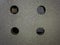 four Drilled holes over a blasted clean grey steel surface
