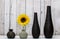 Four Elegant colorful vases with sunflower against cracked wood wall