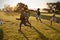 Four elementary school kids playing football in a field