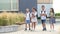 Four elementary school students, two boys and two girls, are walking around the school yard. The children are talking