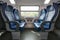 Four empty blue seats facing each other in modern European train. Railroad trip travel or transportation concept
