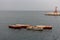 Four empty boats in harbor against lighthouse and white ship on horizone. Transportation background.