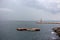Four empty boats in harbor against lighthouse and white ship on horizone. Transportation background.