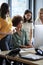 Four female creatives working around a computer monitor in an office, side view, vertical, close up