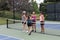 Four Female Pickleball Players Touch Paddles