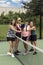 Four Female Pickleball Players Touch Paddles