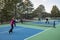 Four Female Pickleball Players Volley near the Net