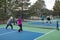 Four Female Pickleball Players Volley near the Net