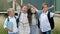 Four friends, elementary school students, stand in an embrace in the schoolyard. Classmates. School friendship.