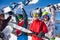 Four friends holding snowboards and skies