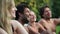 Four friends laughing while sitting in nature