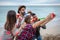 Four friends with red noses take a selfie and celebrate a birthday on the beach