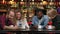 Four friends sitting in a cafe laugh and smile while looking at the screens of phones and exchanging photographs from