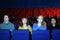 Four friends watch movie in cinema theater