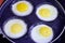 Four frying eggs in a frying pan with salt and pepper, healthy diet eating breakfast