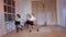 Four girls in black skirts and white shirts are dancing indoors.