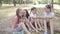 Four girls girlfriends sitting on grass in Park playing and talking