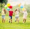 Four glad kids running on green lawn