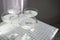Four glasses with champagne on a light table surface reflecting soft sunshine rayson