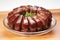 four glazed pork ribs arranged in a half-circle on a round plate