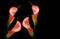 Four glowing pink calla lilies on black background