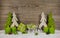 Four green burning christmas candles with presents and trees on