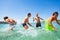 Four happy boys playing at tropical shallow water