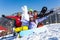 Four happy friends with snowboard and snowman