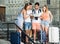 Four happy traveling young people searching for direction using paper map in European town