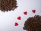 Four hearts lie between two heaps of coffee beans which are apart