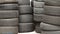 four high stacks of worn and faded used car tires next to one another-