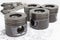 Four identical pistons on white background. spare internal combustion engine