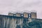 Four industrial metal storage tanks above a wall