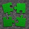 Four jigsaw puzzles of green grass texture, on dry cracked gray land background, high angle view