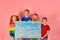 Four joyful children in bright colored clothes hold a wooden boa