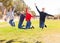 Four joyful teens jump on a lawn