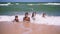 Four kids lying on the beach at the surf