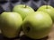 Four large apples, close-up. Fruit on a wooden surface