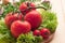 Four large and two small tomatoes, lettuce, garlic in a basket